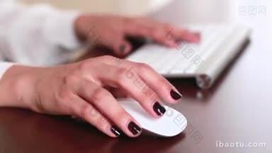 年轻的女商人在办公室的电脑上工作，写电子邮件，<strong>点击</strong>鼠标与背景散焦